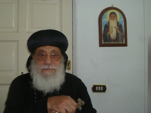 Bishop Antonious Marcos, missionary bishop for Africa. Behind him is a picture of the Coptic saint know as St. Moses the black.
