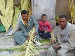 This is a good photo to close with, Coptic street vendors making palm leaves outside a church in Asyut. The little cross the man on the right is holding sold for $1.